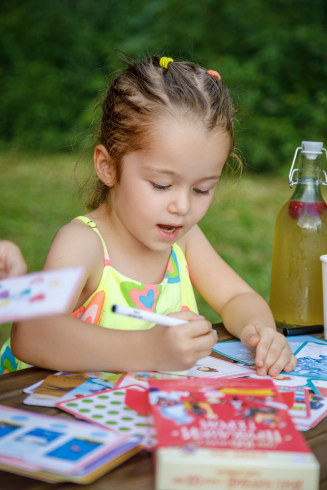 a girl playing with educational cards Clever Book
